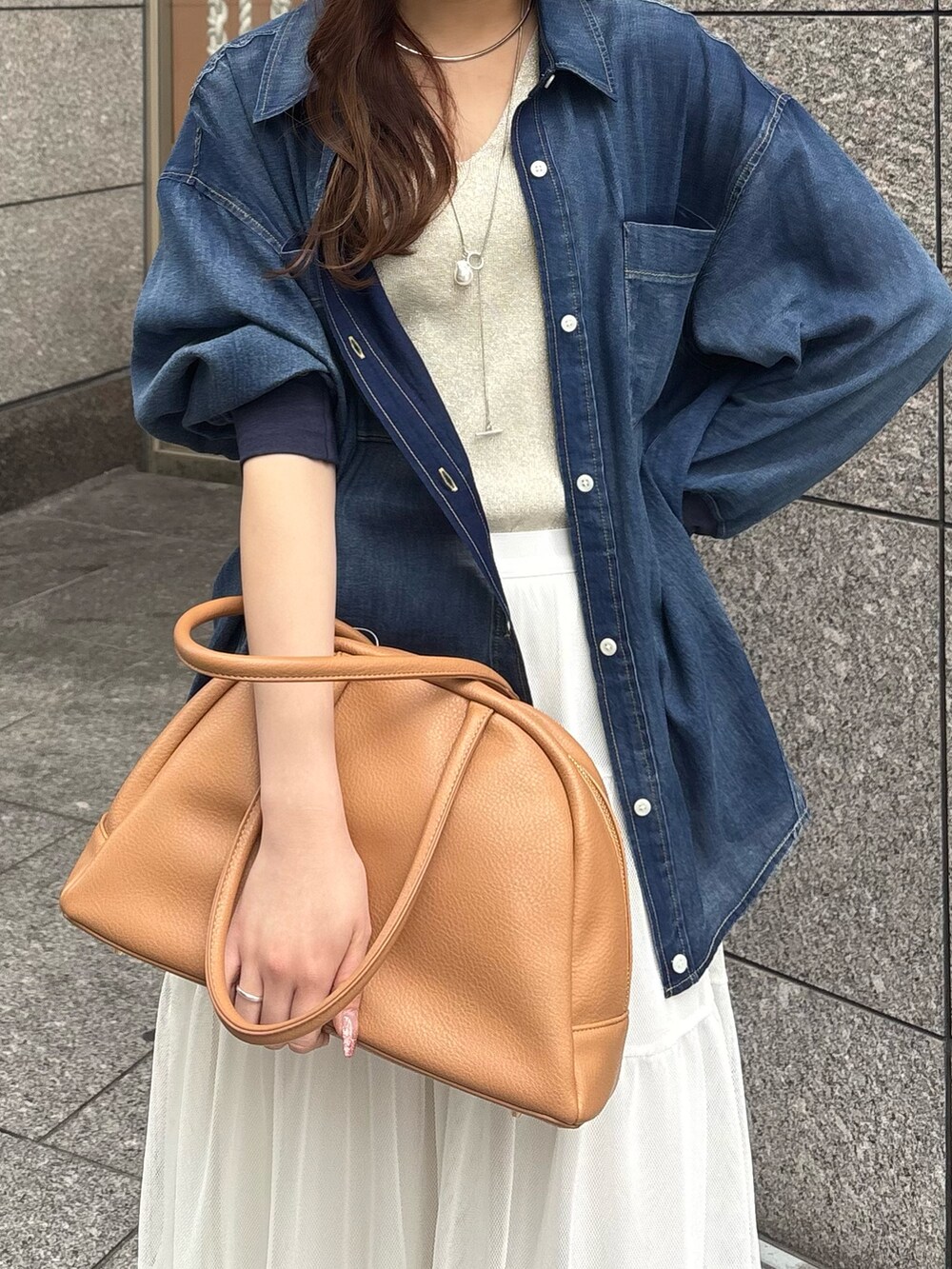 ホワイト系のスカート、ブルー系のシャツ/ブラウス、ベージュ系のニット/セーターを着用したレディースの春コーディネートの3枚目の写真