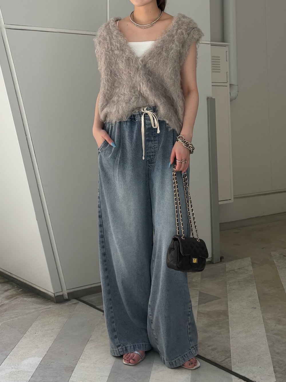 ベージュ系のニット/セーター、ブルー系のその他パンツ、ブラック系のショルダーバッグを着用したレディースの夏コーディネートの2枚目の写真