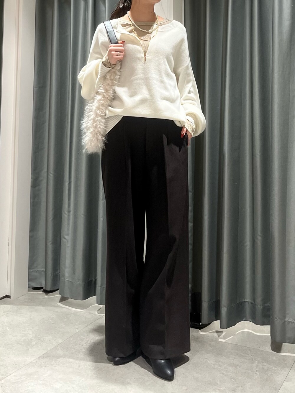 ホワイト系のニット/セーター、ゴールド系のTシャツ/カットソー、ブラウン系のその他パンツを着用したレディースの冬コーディネートの4枚目の写真