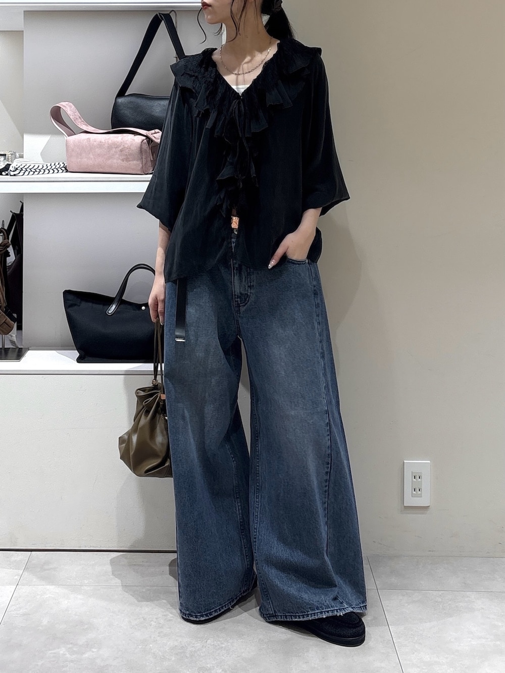 ブラック系のその他シューズ、ブルー系のデニムパンツ、グリーン系のトートバッグを着用したレディースの秋コーディネートの2枚目の写真
