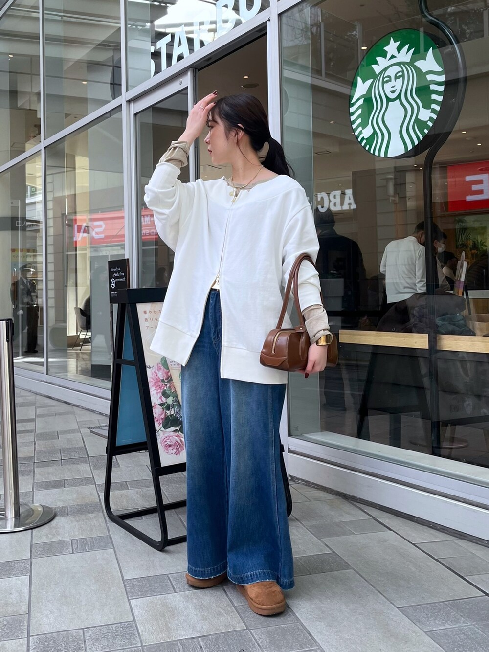 ブルー系のデニムパンツ、ベージュ系のその他アウター、ホワイト系のTシャツ/カットソーを着用したレディースの冬コーディネートの2枚目の写真