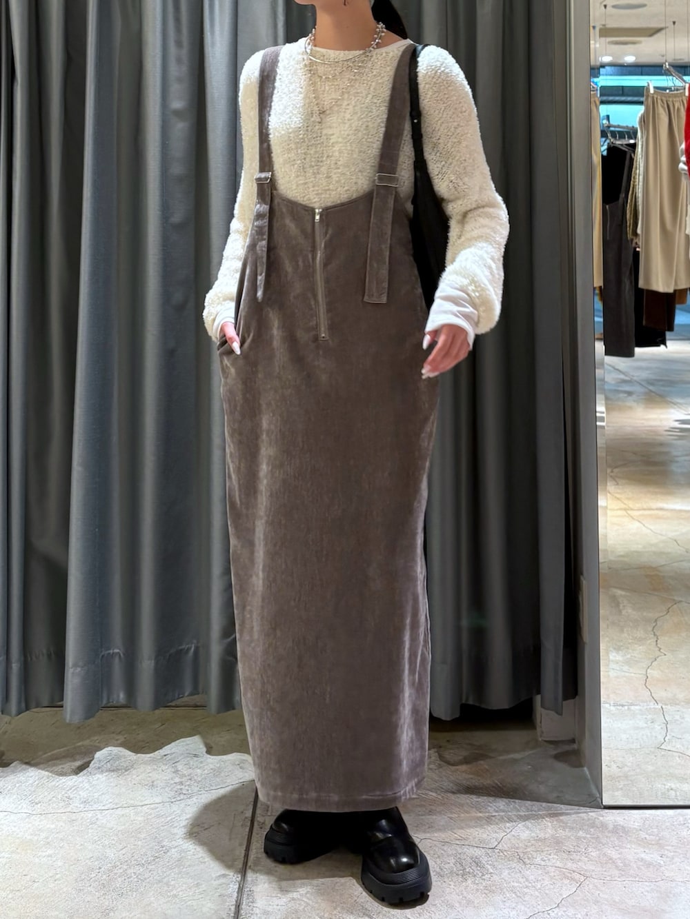 ベージュ系のワンピース、ブラック系のブーツ、ホワイト系のTシャツ/カットソーを着用したレディースの冬コーディネートの3枚目の写真