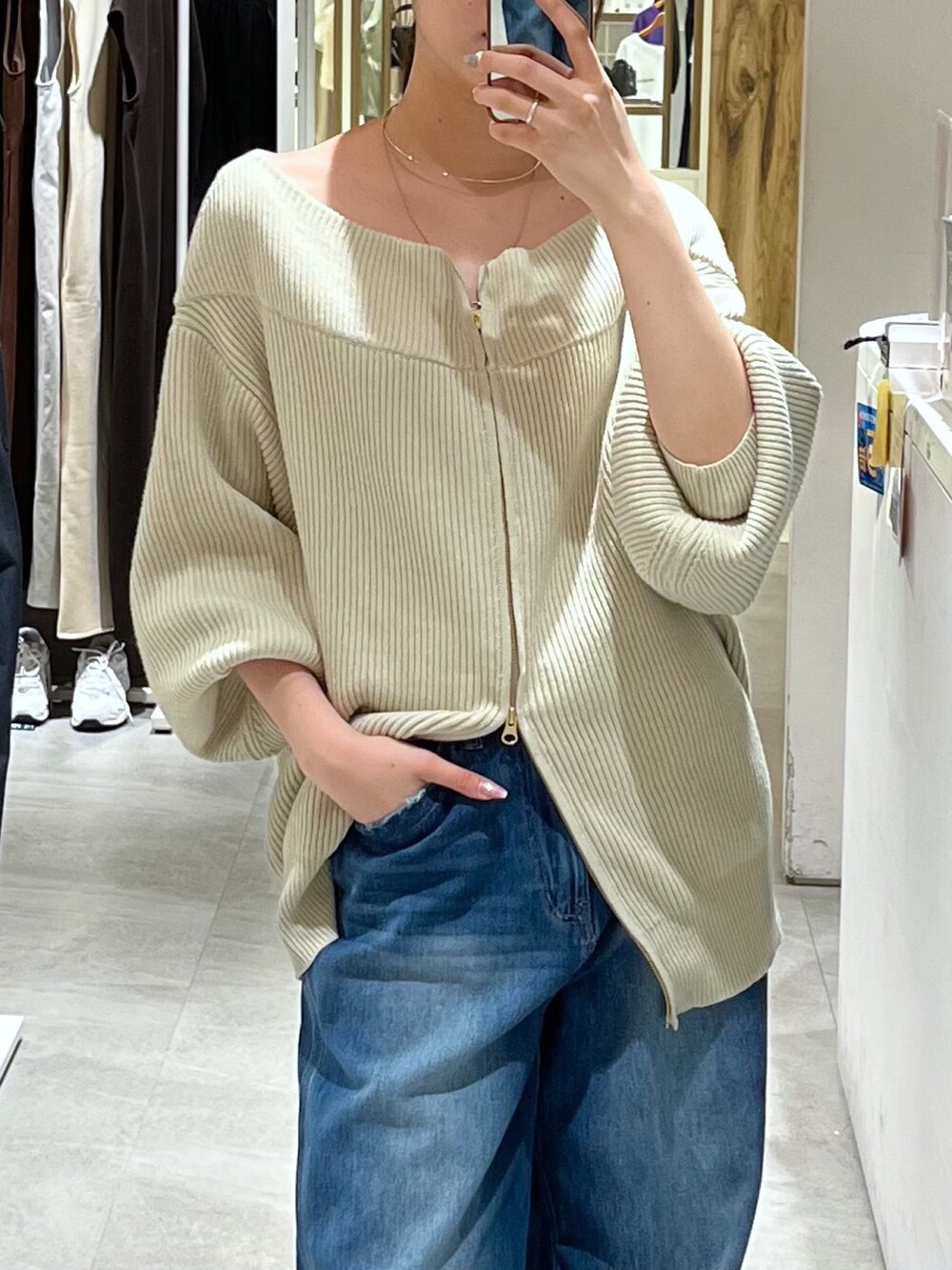 ベージュ系のニット/セーター、ブルー系のデニムパンツ、シルバー系のパンプスを着用したレディースの秋コーディネートの4枚目の写真