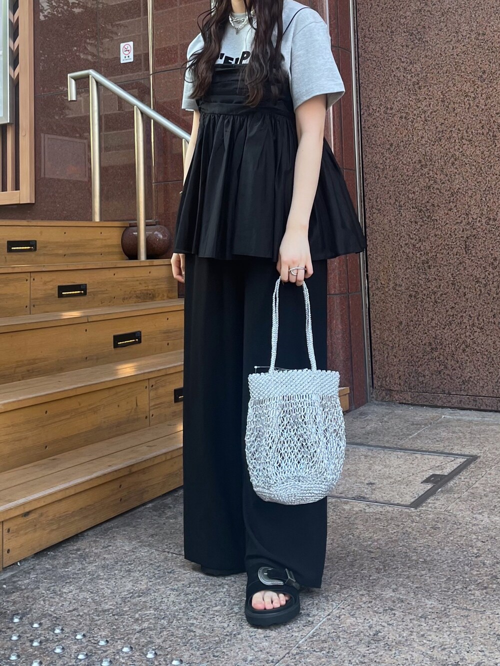 グレー系のTシャツ/カットソー、ブラック系のパンツ、ブラック系のキャミソールを着用したレディースの夏コーディネートの6枚目の写真