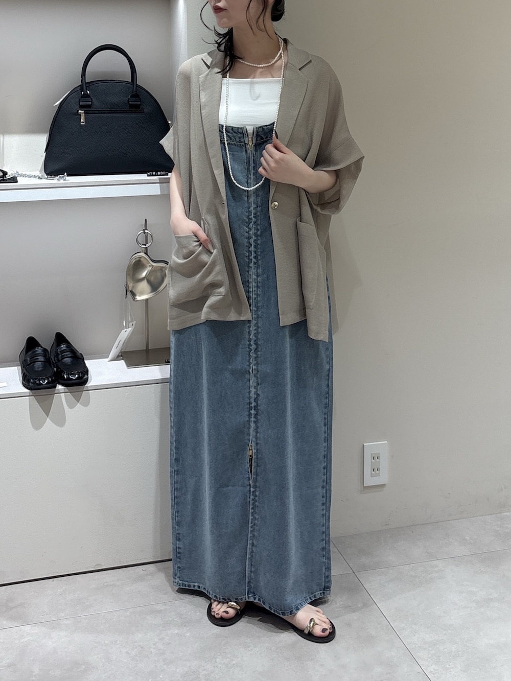 ブルー系のワンピース、ベージュ系のテーラードジャケット、ホワイト系のTシャツ/カットソーを着用したレディースの春コーディネートの2枚目の写真