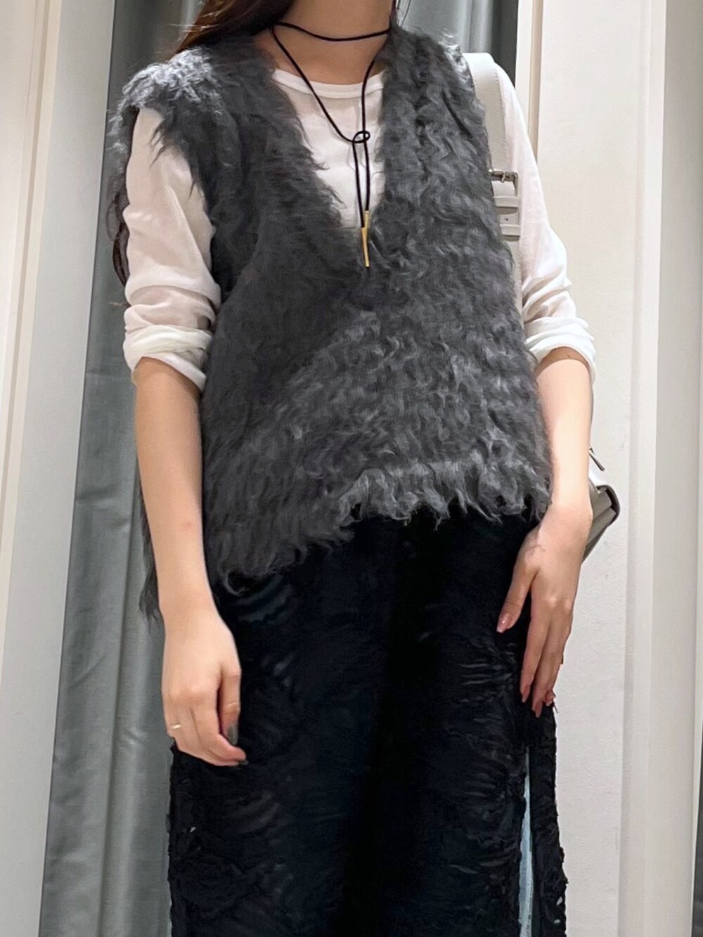 ブルー系のデニムパンツ、シルバー系のパンプス、グレー系のニット/セーターを着用したレディースの秋コーディネートの5枚目の写真