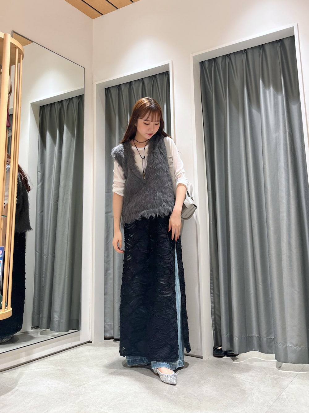 ブルー系のデニムパンツ、シルバー系のパンプス、グレー系のニット/セーターを着用したレディースの秋コーディネートの2枚目の写真