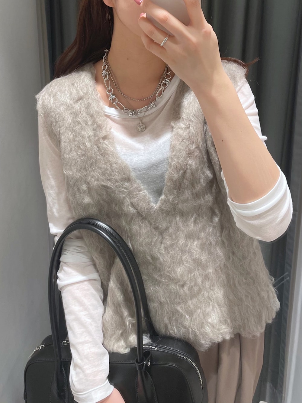 ブラウン系のスラックス、ベージュ系のニット/セーター、ホワイト系のTシャツ/カットソーを着用したレディースの秋コーディネートの5枚目の写真