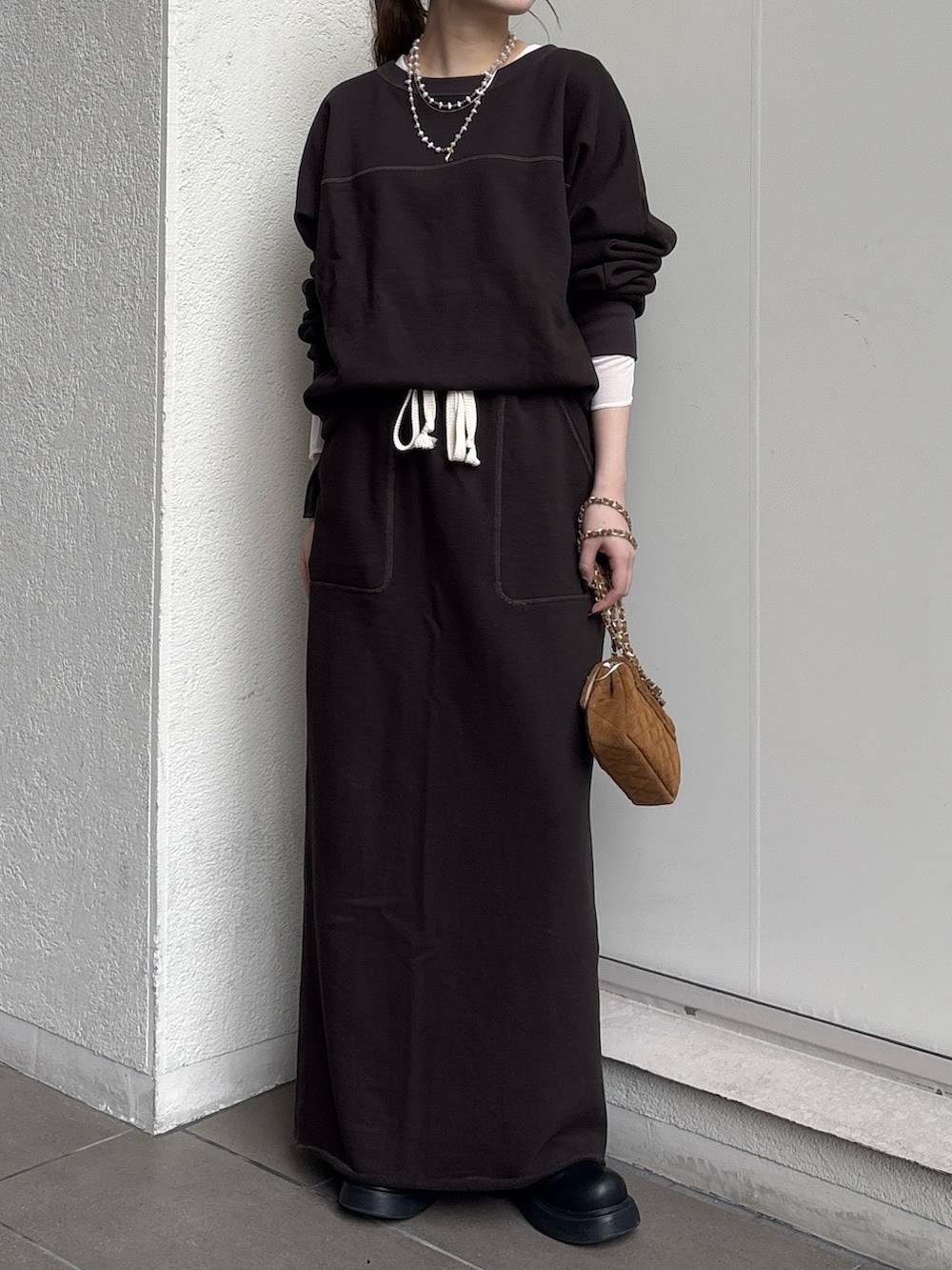 ブラウン系のスカート、イエロー系のショルダーバッグ、ブラウン系のスウェットを着用したレディースの秋コーディネートの4枚目の写真