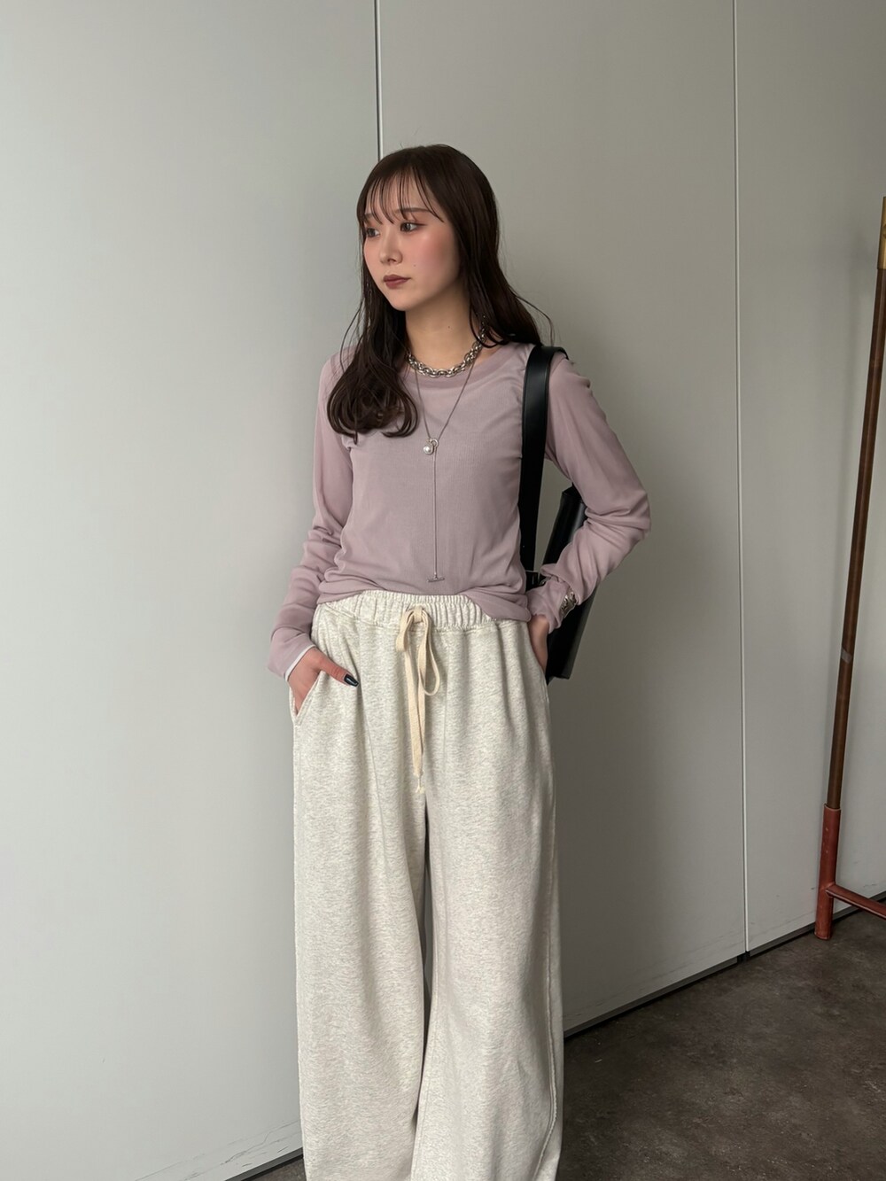 グレー系のその他パンツ、グレー系のTシャツ/カットソー、シルバー系のネックレスを着用したレディースの冬コーディネートの2枚目の写真