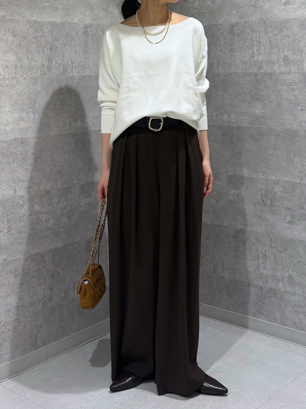 ホワイト系のニット/セーター、ブラウン系のスラックス、ブラウン系のパンプスを着用したレディースの冬コーディネートの4枚目の写真