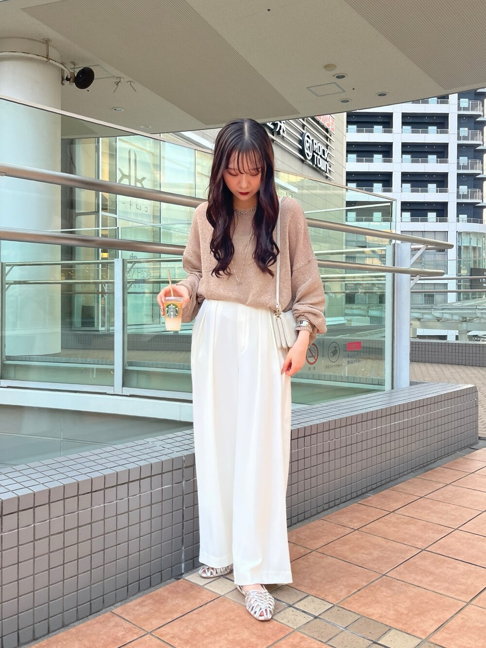 ブラウン系のニット/セーター、ホワイト系のスラックス、シルバー系のパンプスを着用したレディースの夏コーディネートの2枚目の写真