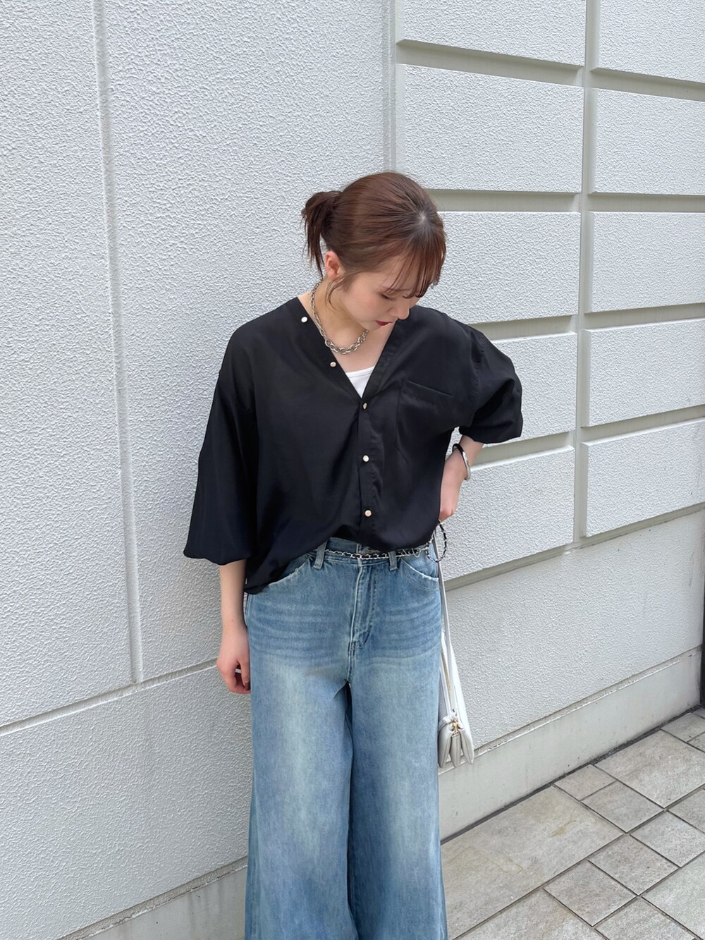 ブルー系のデニムパンツ、ブラック系のシャツ/ブラウス、ホワイト系のショルダーバッグを着用したレディースの夏コーディネートの3枚目の写真