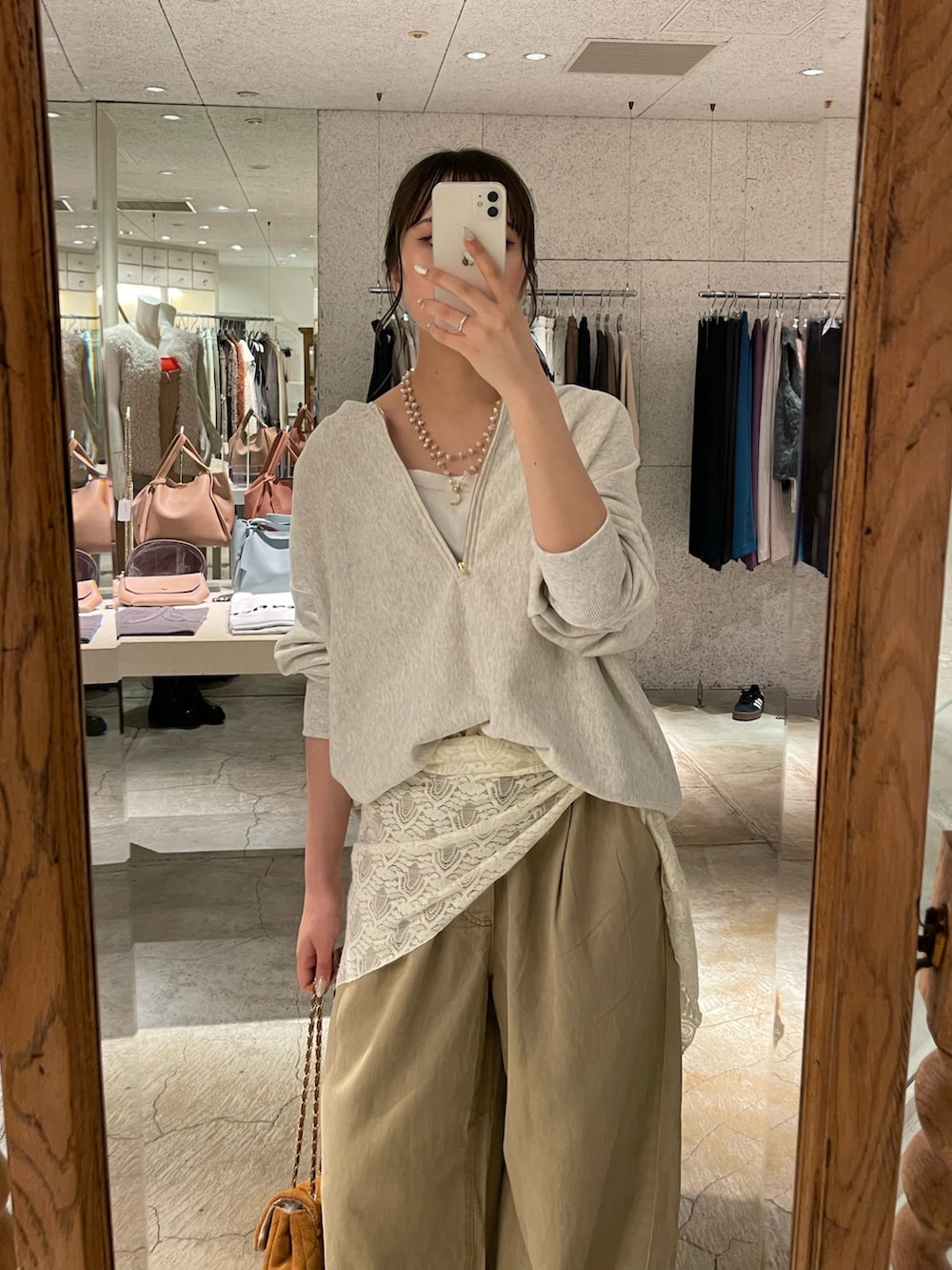 ベージュ系のデニムパンツ、イエロー系のショルダーバッグ、ベージュ系のスウェットを着用したレディースの秋コーディネートの2枚目の写真