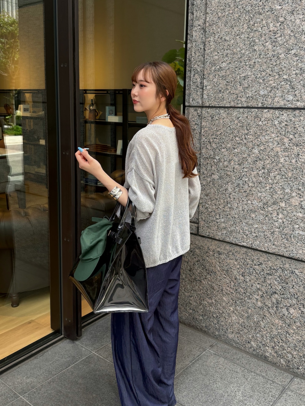 ブルー系のその他パンツ、ブラック系のショルダーバッグ、グレー系のニット/セーターを着用したレディースの夏コーディネートの2枚目の写真