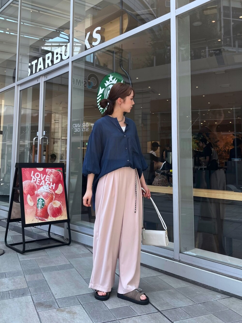 ピンク系のスラックス、ブルー系のシャツ/ブラウス、ホワイト系のタンクトップを着用したレディースの夏コーディネートの5枚目の写真