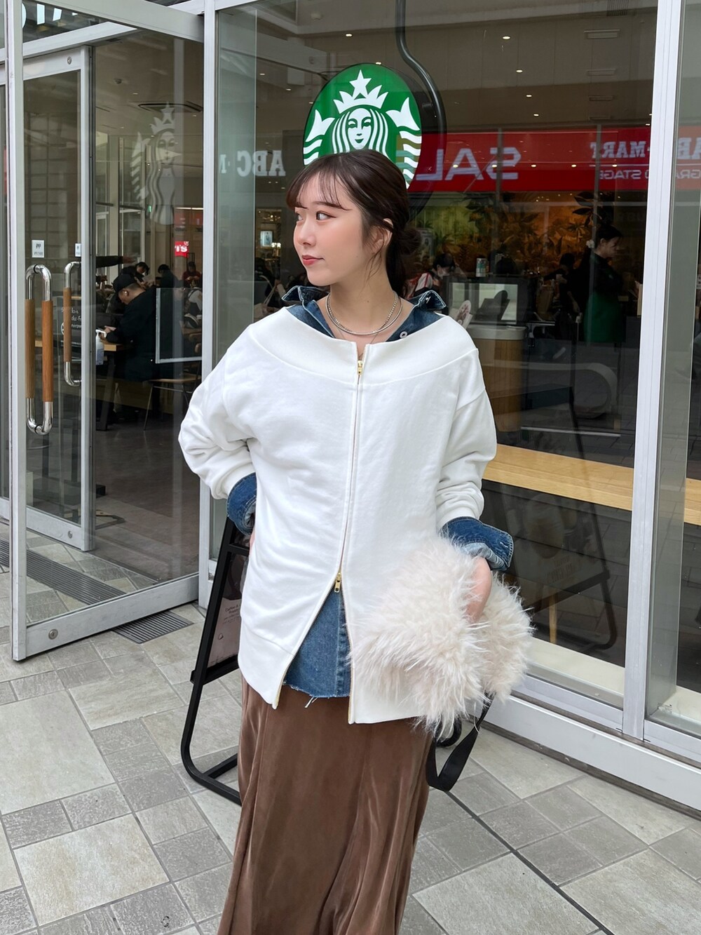 ブラウン系のスカート、ブラック系のブーツ、ホワイト系のTシャツ/カットソーを着用したレディースの冬コーディネートの3枚目の写真