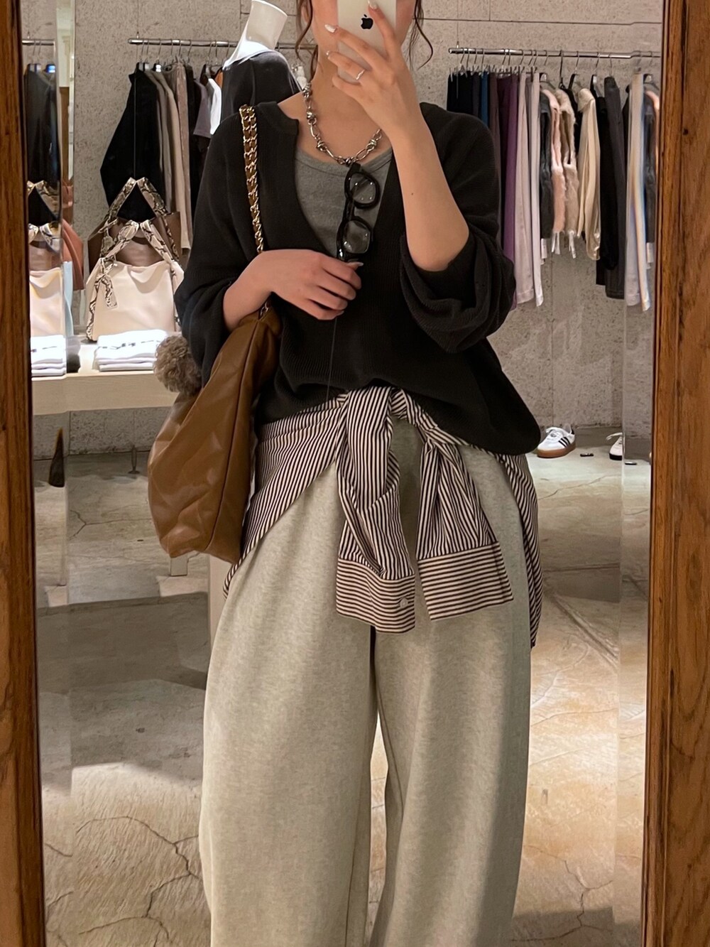 グレー系のニット/セーター、イエロー系のショルダーバッグ、グレー系のシャツ/ブラウスを着用したレディースの秋コーディネートの3枚目の写真