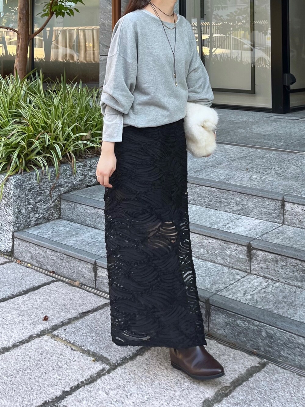 ブラウン系のブーツ、シルバー系のTシャツ/カットソー、グレー系のスウェットを着用したレディースの秋コーディネートの3枚目の写真