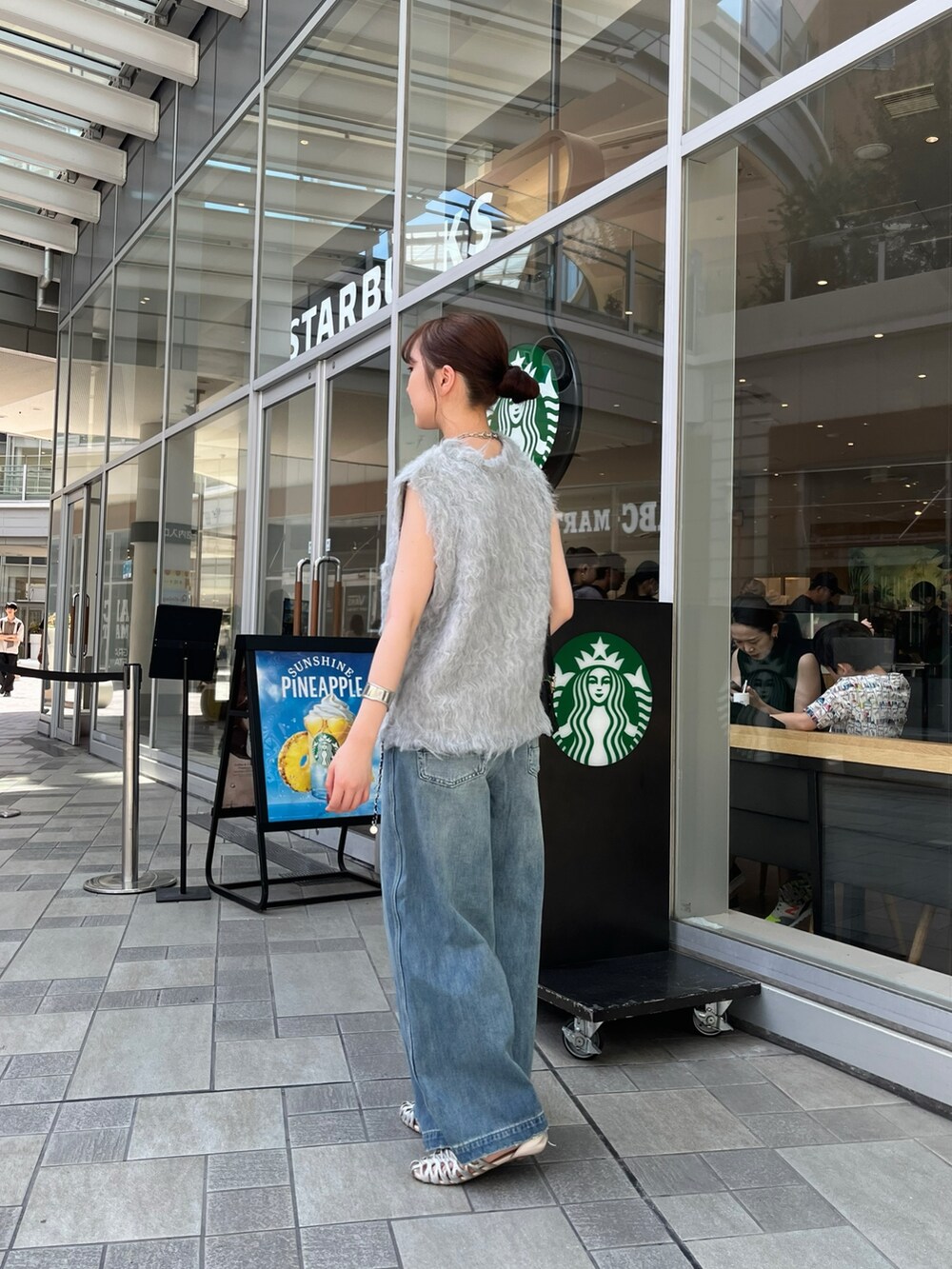 ブルー系のデニムパンツ、シルバー系のパンプス、ブルー系のキャミソールを着用したレディースの夏コーディネートの2枚目の写真