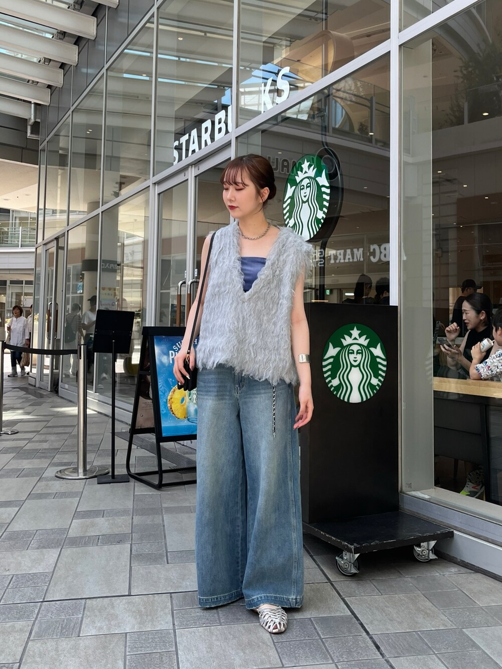 ブルー系のデニムパンツ、シルバー系のパンプス、ブルー系のキャミソールを着用したレディースの夏コーディネートの4枚目の写真