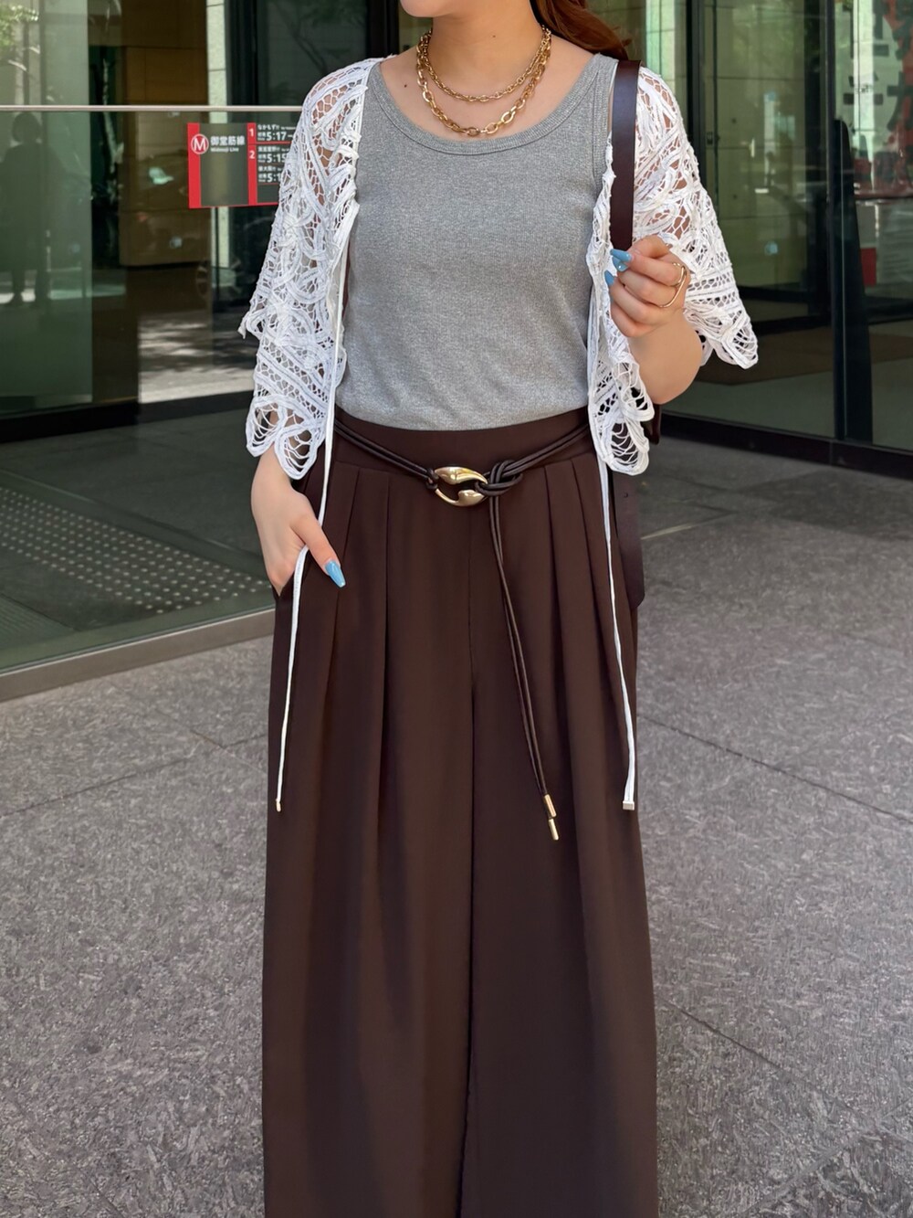 ブラウン系のスラックス、ブラック系のサンダル、グレー系のTシャツ/カットソーを着用したレディースの夏コーディネートの5枚目の写真