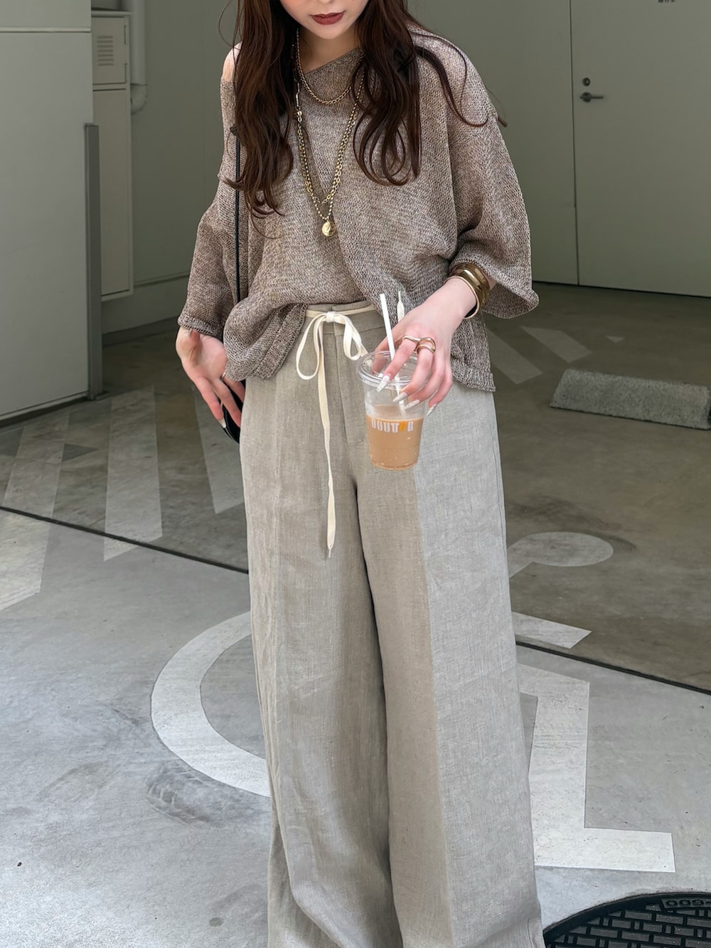 ベージュ系のその他パンツ、ベージュ系のニット/セーター、ブラック系のショルダーバッグを着用したレディースの春コーディネートの4枚目の写真