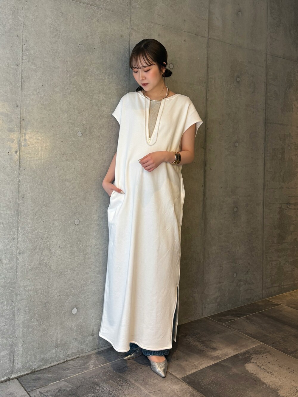 ホワイト系のワンピース、ブルー系のデニムパンツ、ベージュ系のニット/セーターを着用したレディースの春コーディネートの5枚目の写真