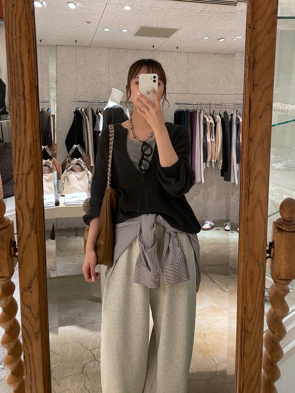 グレー系のニット/セーター、イエロー系のショルダーバッグ、グレー系のシャツ/ブラウスを着用したレディースの秋コーディネートの2枚目の写真