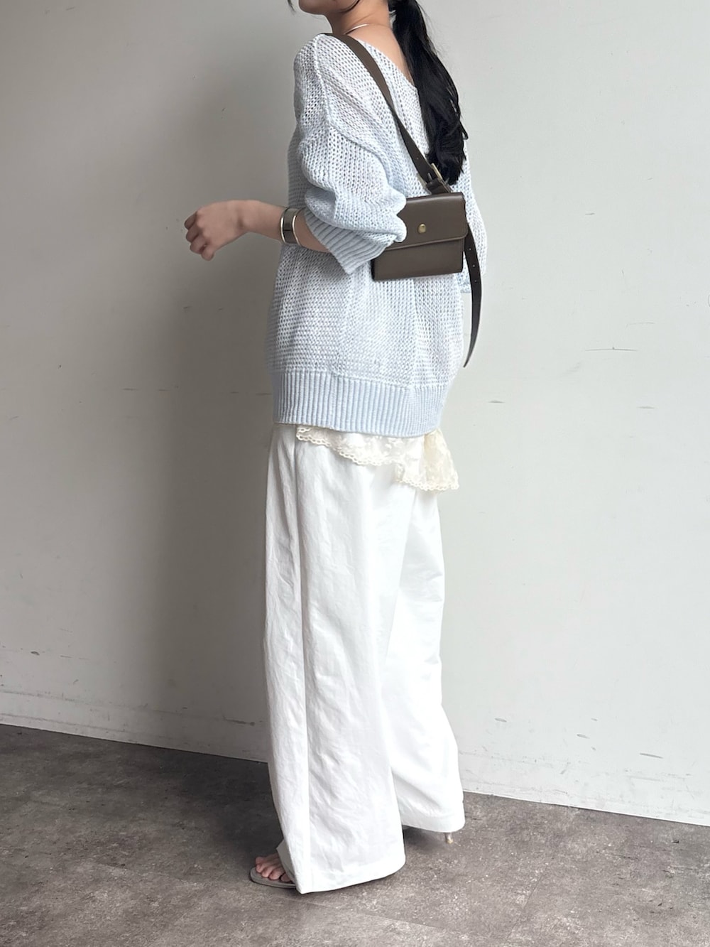 ブルー系のニット/セーター、シルバー系のネックレスを着用したレディースの春コーディネートの3枚目の写真