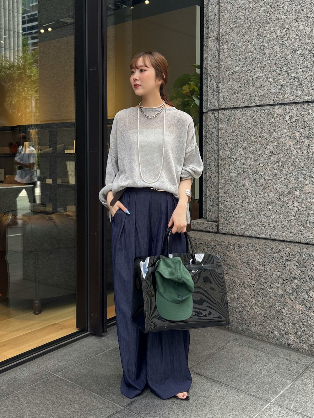 ブルー系のその他パンツ、ブラック系のショルダーバッグ、グレー系のニット/セーターを着用したレディースの夏コーディネートの3枚目の写真