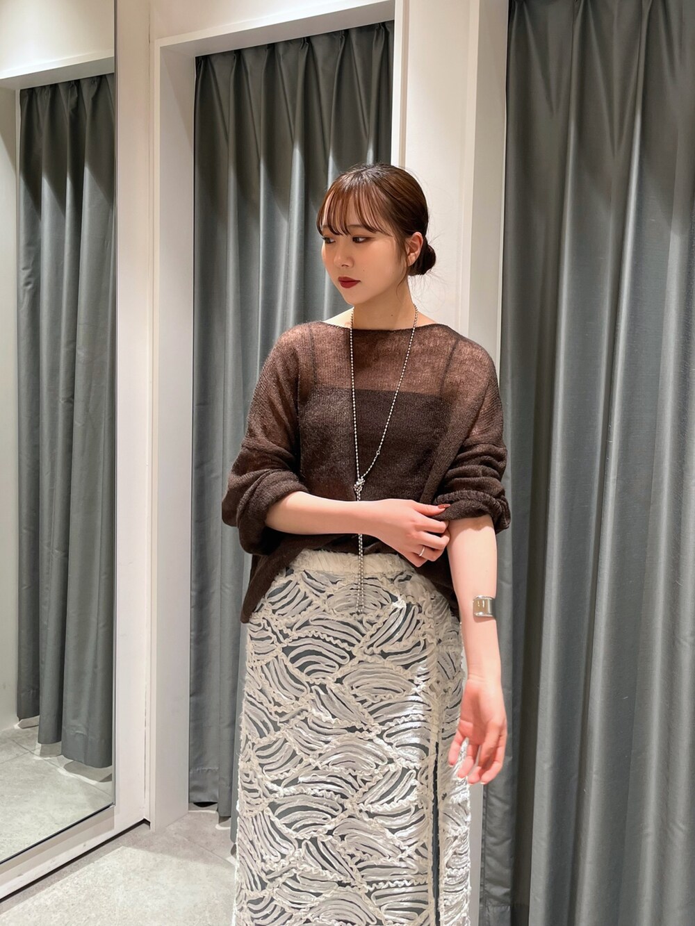 ブルー系のデニムパンツ、シルバー系のバレエシューズ、ホワイト系のスカートを着用したレディースの夏コーディネートの3枚目の写真