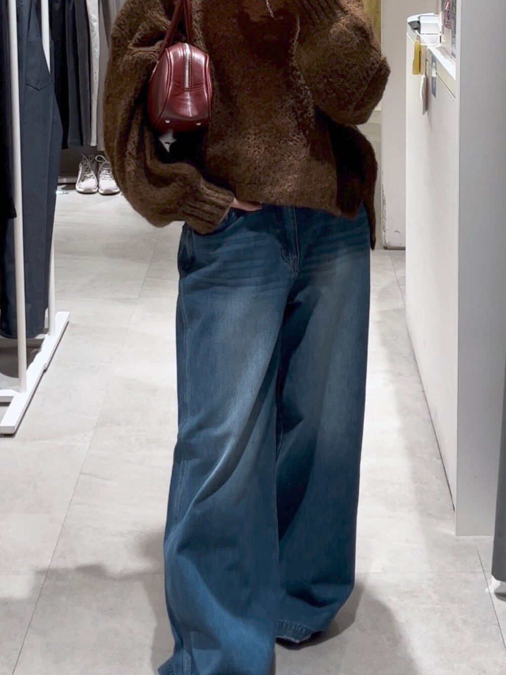 ブルー系のデニムパンツ、ピンク系のバレエシューズ、レッド系のTシャツ/カットソーを着用したレディースの秋コーディネートの2枚目の写真