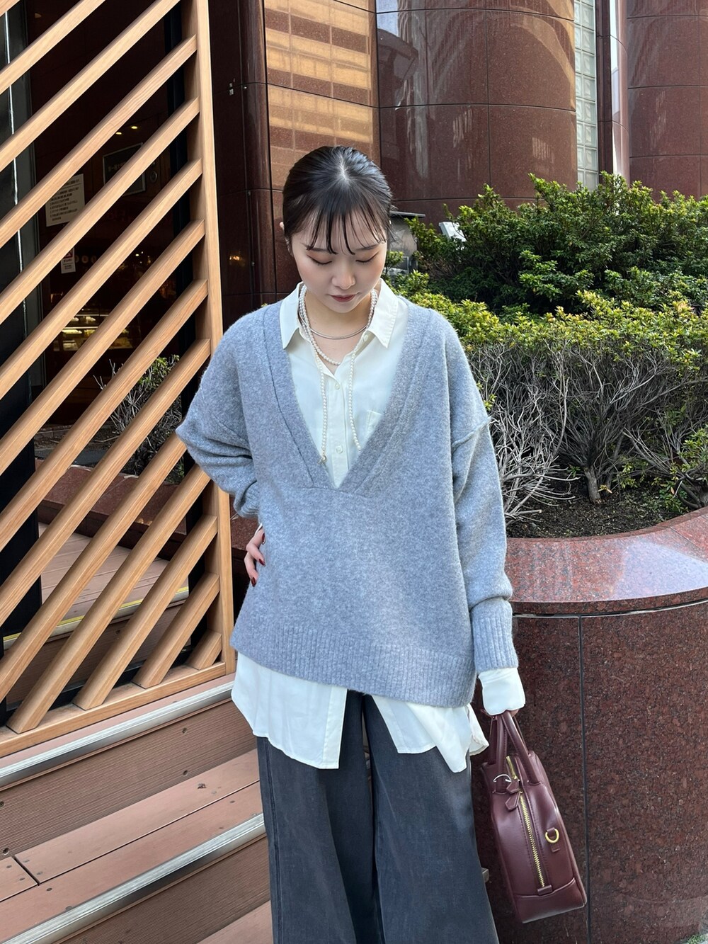 ブラック系のデニムパンツ、ブラウン系のショルダーバッグ、グレー系のその他アウターを着用したレディースの冬コーディネートの3枚目の写真