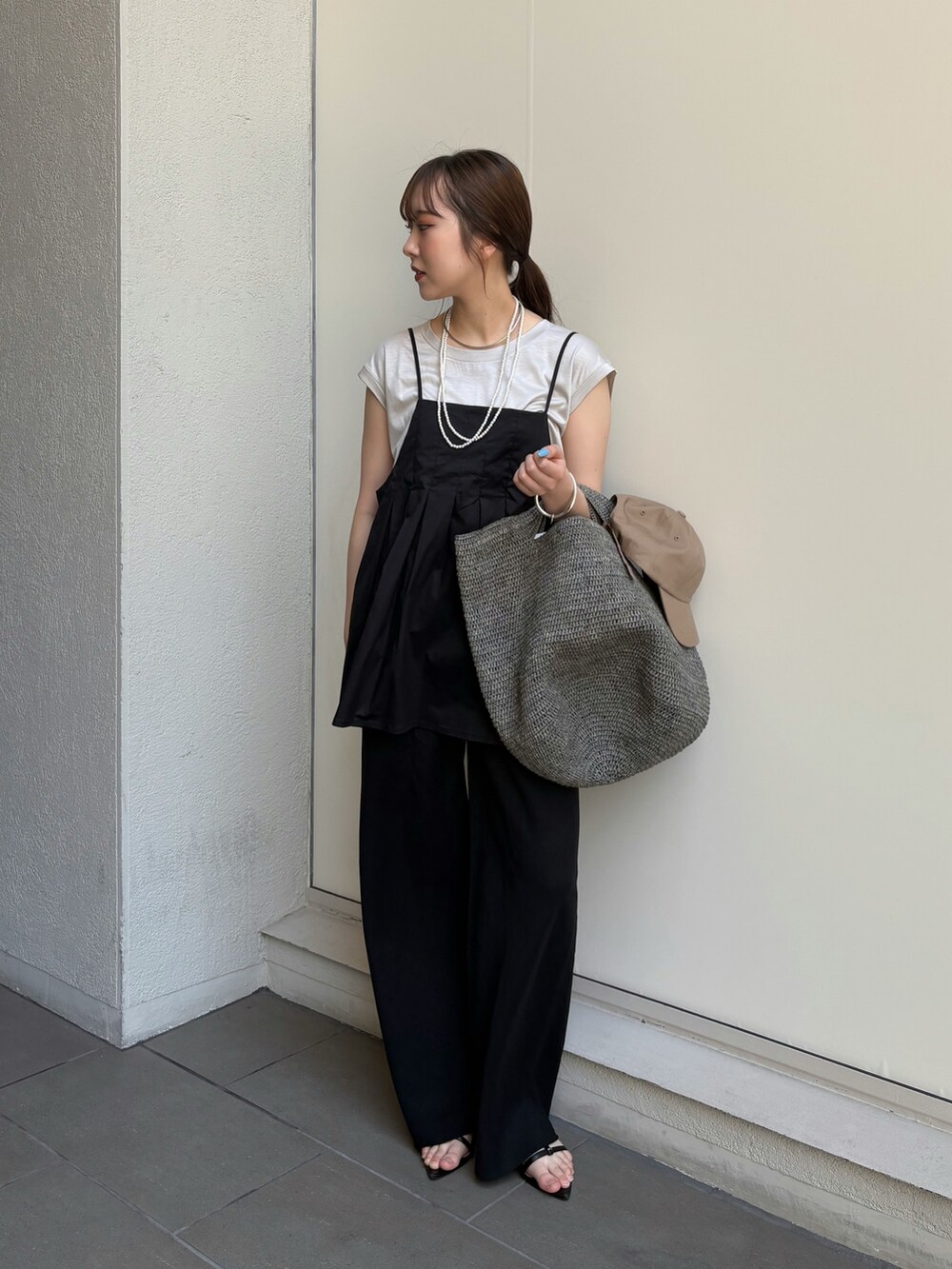 ブラック系のその他パンツ、ブラック系のサンダル、ベージュ系のTシャツ/カットソーを着用したレディースの夏コーディネートの4枚目の写真