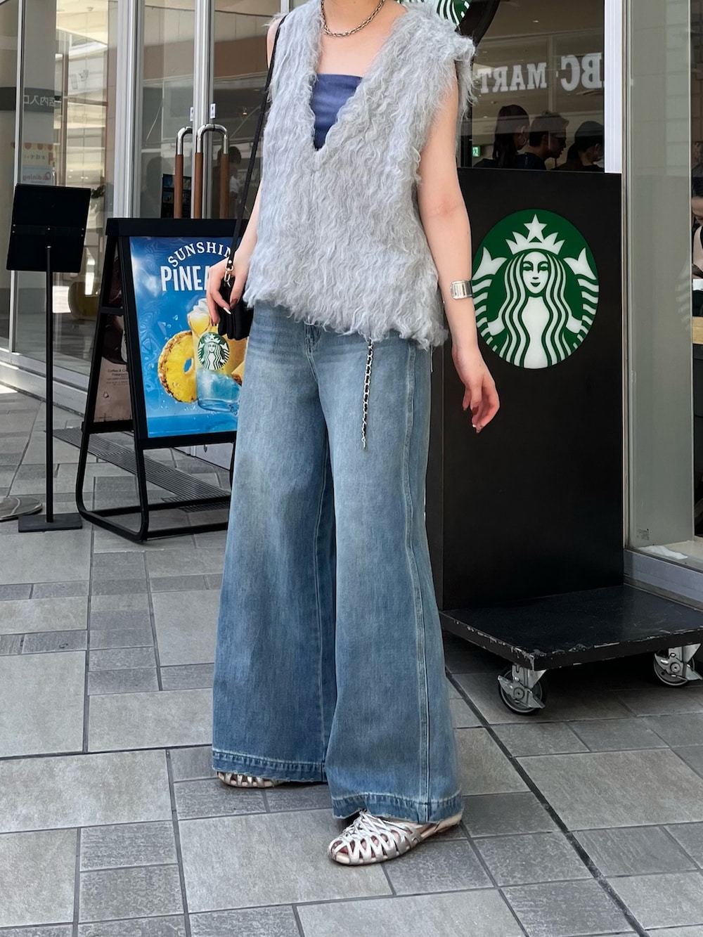 ブルー系のデニムパンツ、シルバー系のパンプス、ブルー系のキャミソールを着用したレディースの夏コーディネートの5枚目の写真