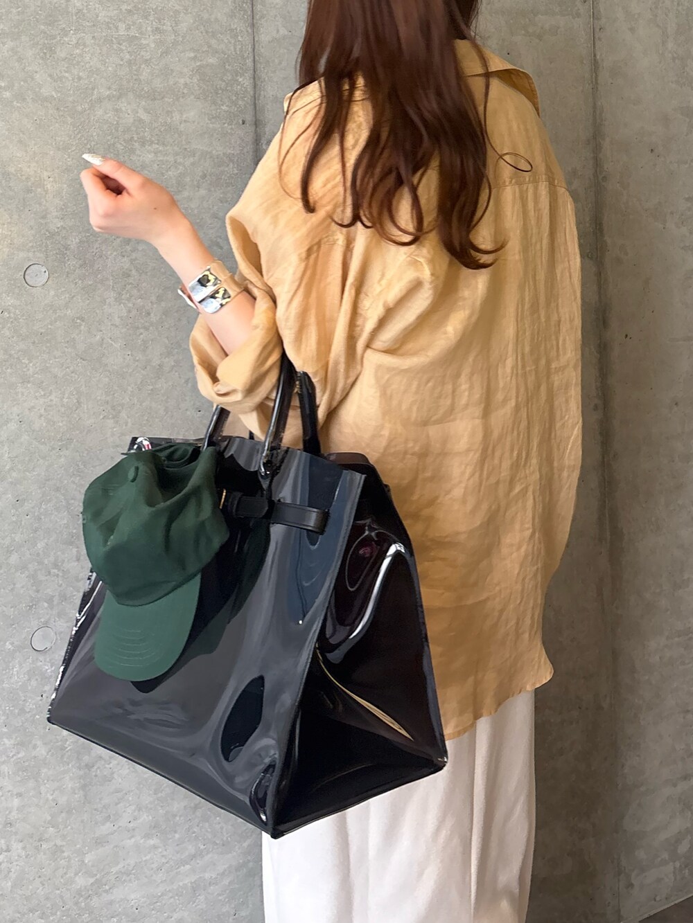 ベージュ系のワンピース、ブラック系のショルダーバッグ、ベージュ系のシャツ/ブラウスを着用したレディースの春コーディネートの4枚目の写真