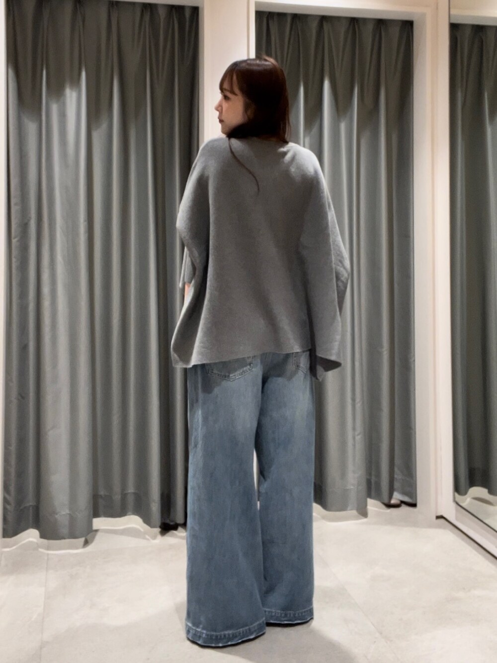 ブルー系のデニムパンツ、シルバー系のパンプス、ブラウン系のショルダーバッグを着用したレディースの秋コーディネートの2枚目の写真