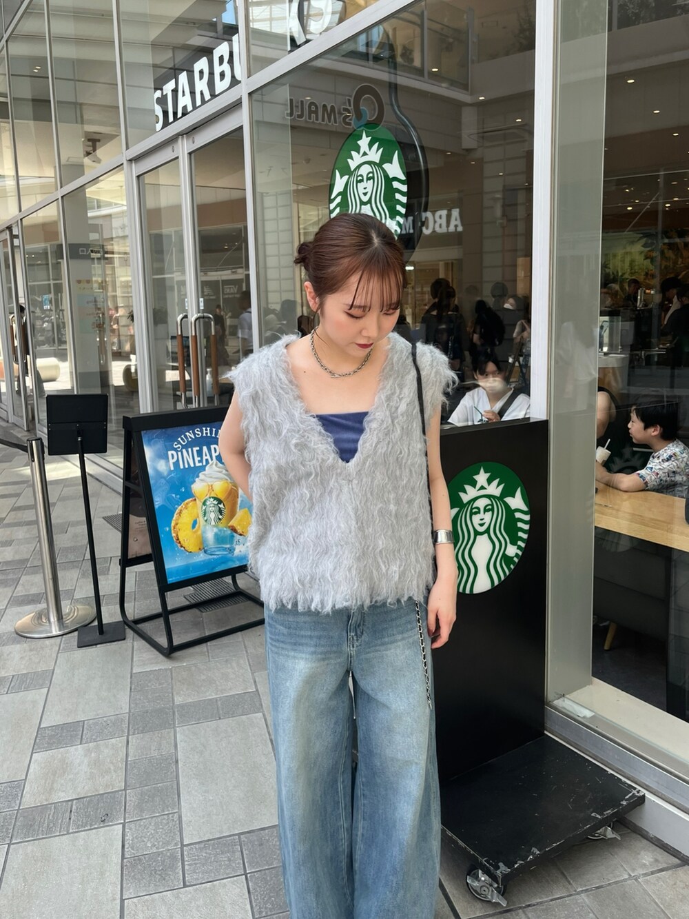 ブルー系のデニムパンツ、シルバー系のパンプス、ブルー系のキャミソールを着用したレディースの夏コーディネートの3枚目の写真