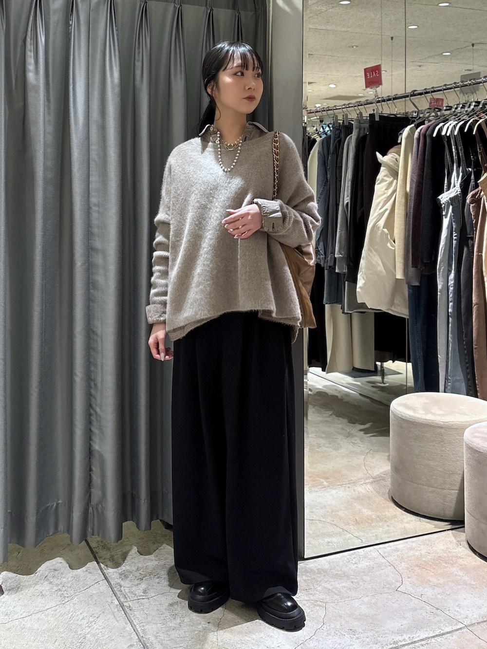 ブラウン系のニット/セーター、ブラック系のその他パンツ、ブラック系のブーツを着用したレディースの冬コーディネートの2枚目の写真