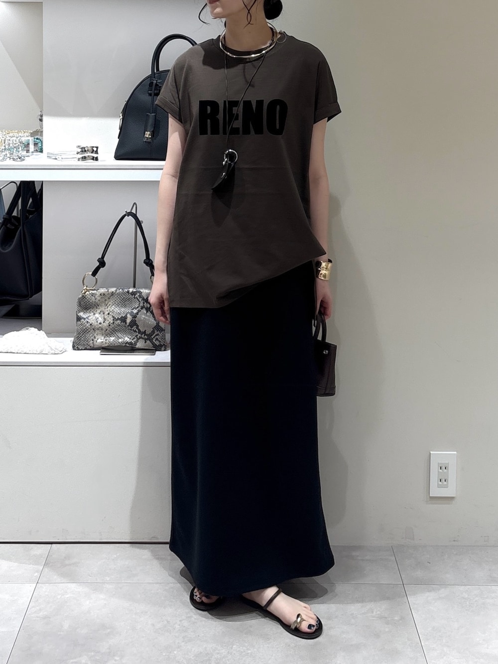 ブラウン系のショルダーバッグ、ブラック系のワンピース、ブラウン系のTシャツ/カットソーを着用したレディースの夏コーディネートの2枚目の写真
