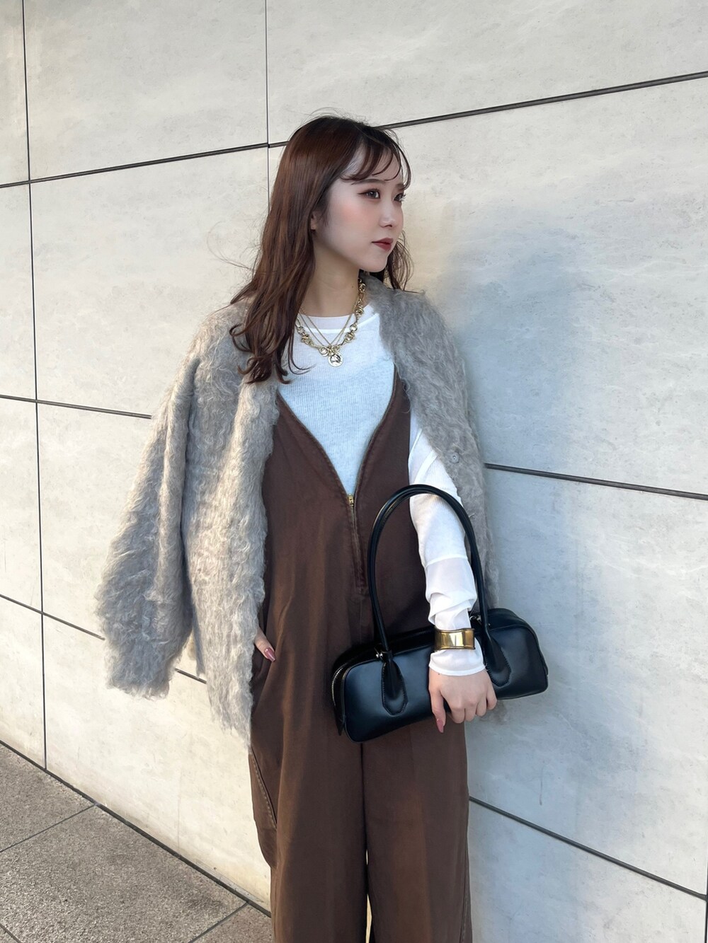 ブラウン系のつなぎ/オールインワン、ベージュ系のカーディガン/ボレロ、ホワイト系のTシャツ/カットソーを着用したレディースの秋コーディネートの2枚目の写真