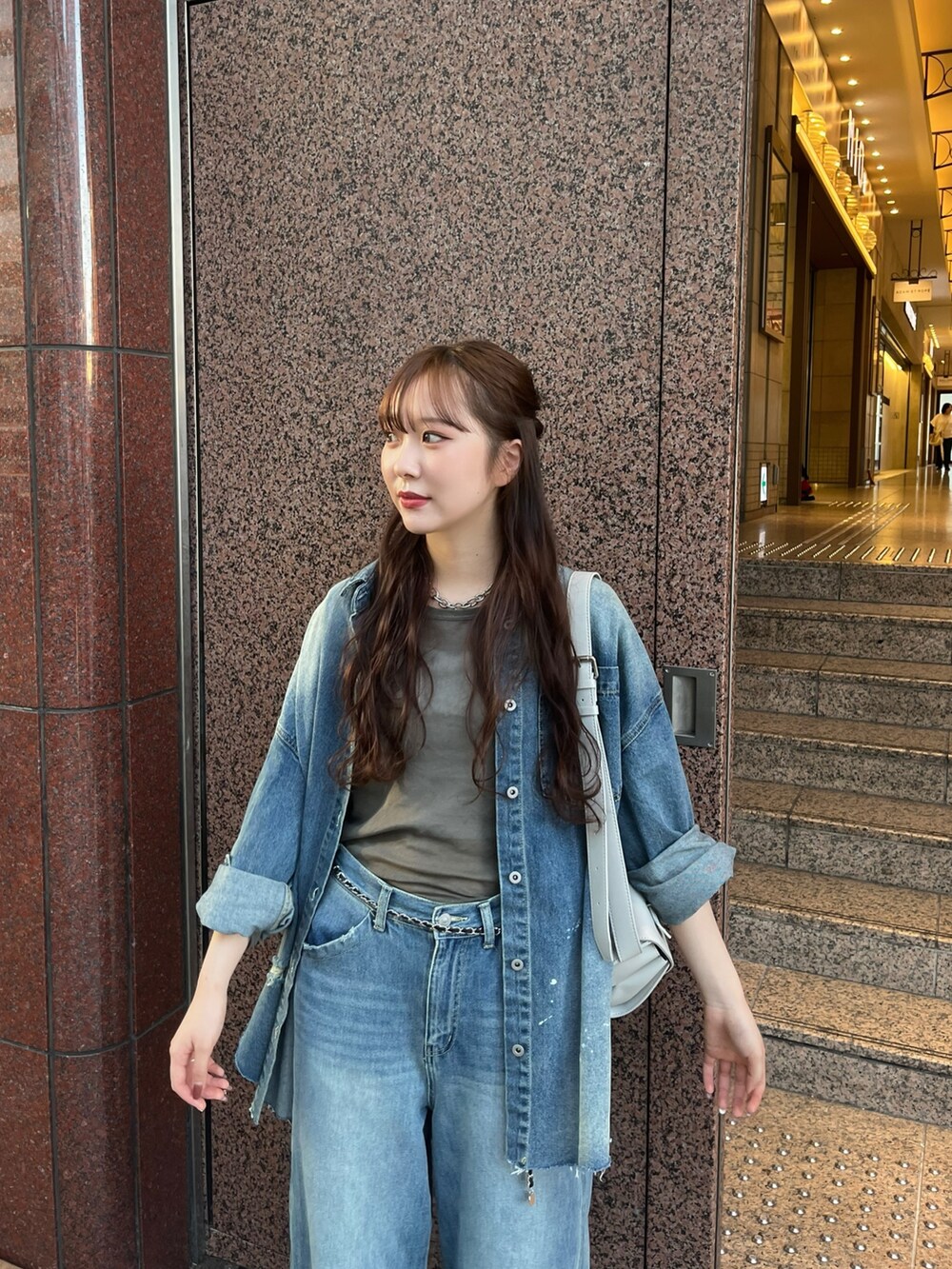 ブルー系のデニムパンツ、シルバー系のパンプス、ブルー系のシャツ/ブラウスを着用したレディースの秋コーディネートの2枚目の写真