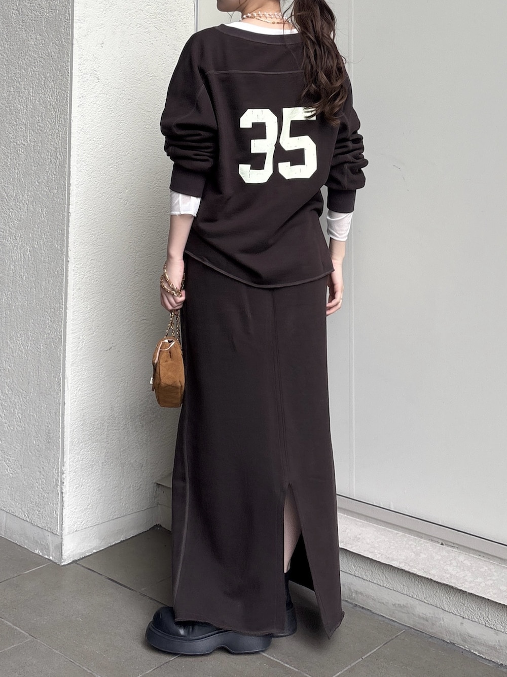 ブラウン系のスカート、イエロー系のショルダーバッグ、ブラウン系のスウェットを着用したレディースの秋コーディネートの3枚目の写真