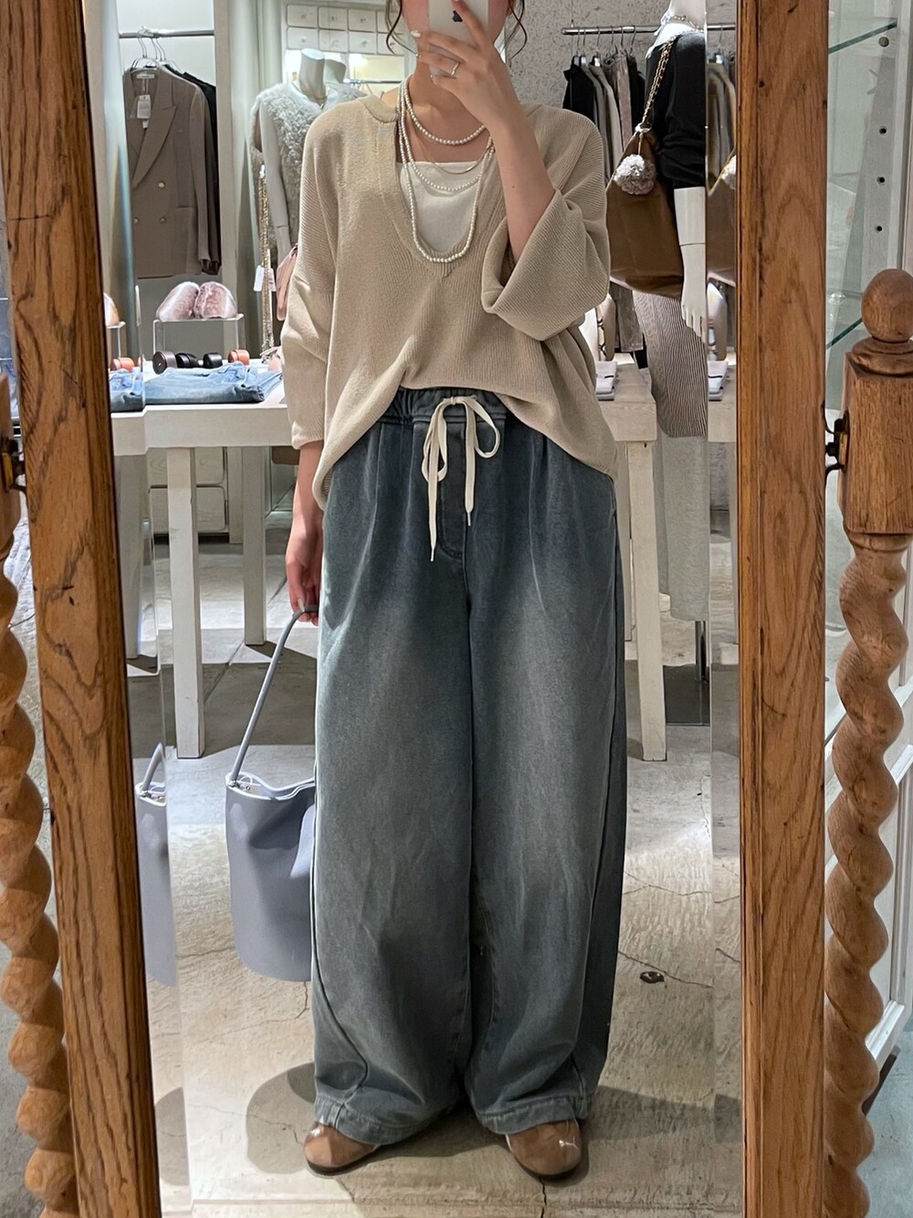 ブルー系のショルダーバッグ、ブルー系のその他パンツ、ベージュ系のニット/セーターを着用したレディースの秋コーディネートの3枚目の写真