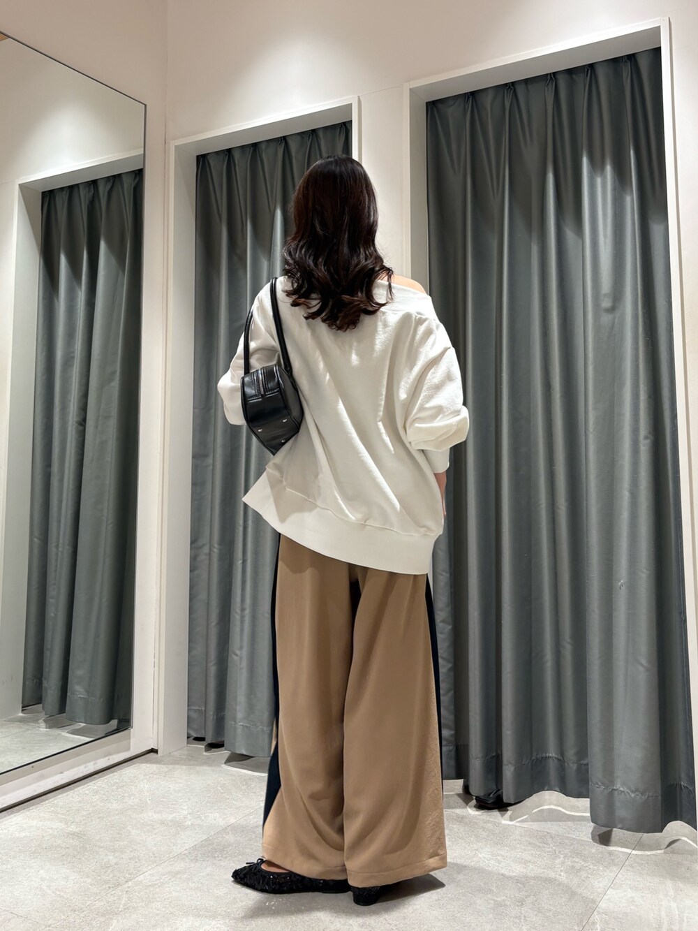 ベージュ系のその他パンツ、ホワイト系のTシャツ/カットソー、ブラック系のショルダーバッグを着用したレディースの冬コーディネートの4枚目の写真