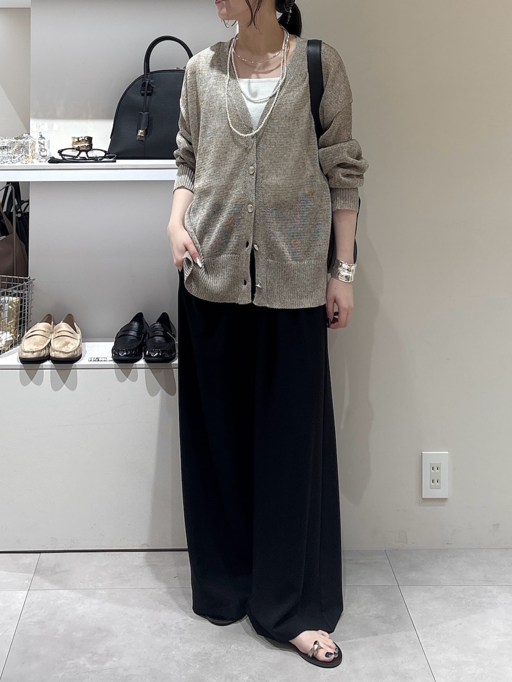 ブラック系のその他パンツ、ベージュ系のカーディガン/ボレロ、ブラック系のショルダーバッグを着用したレディースの夏コーディネートの2枚目の写真