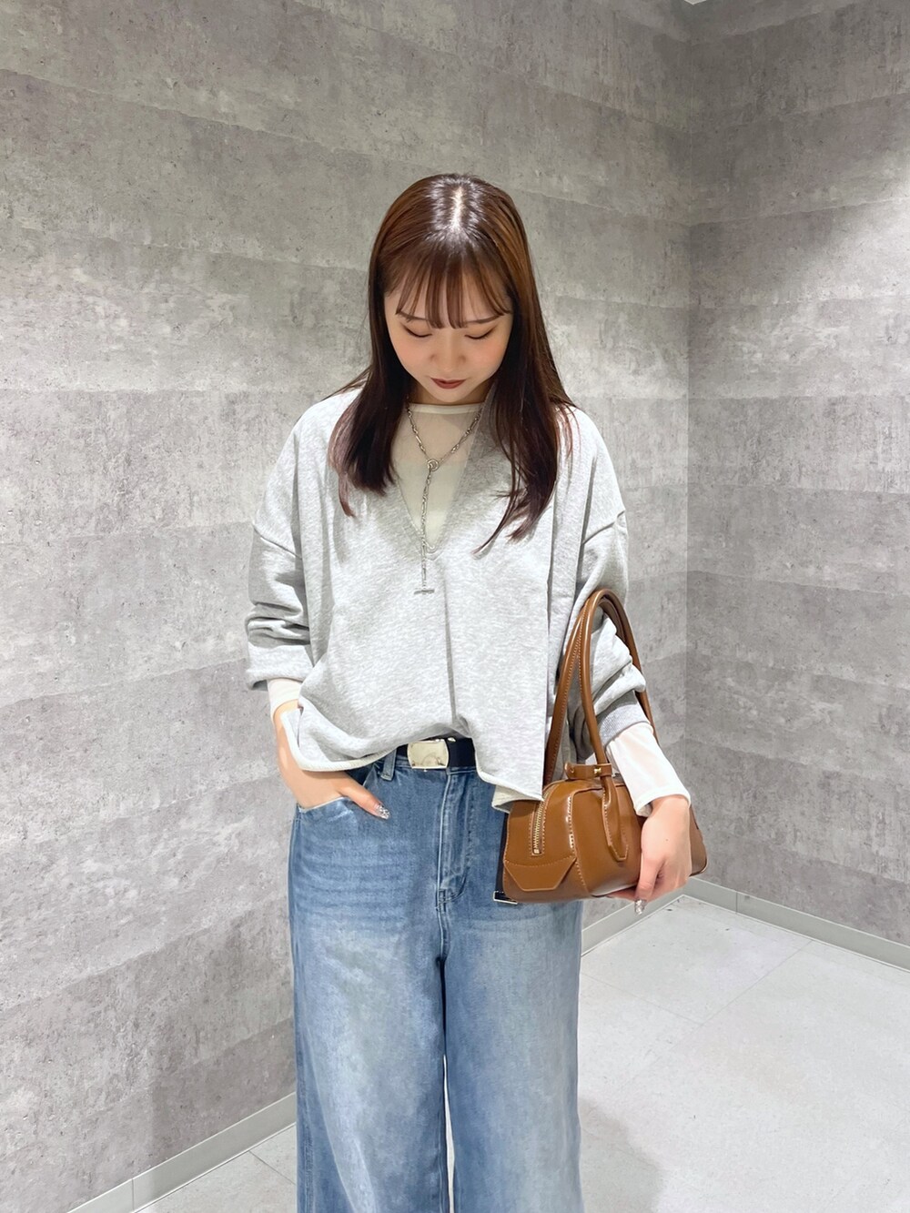 ブルー系のデニムパンツ、シルバー系のパンプス、グレー系のTシャツ/カットソーを着用したレディースの秋コーディネートの3枚目の写真