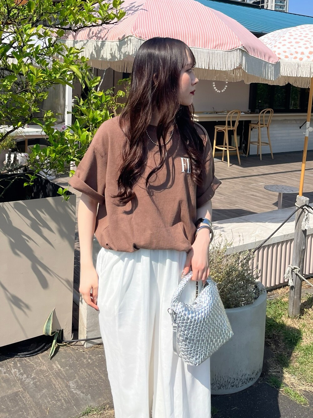 ブラウン系のTシャツ/カットソー、ホワイト系のパンツ、シルバー系のサンダルを着用したレディースの夏コーディネートの4枚目の写真