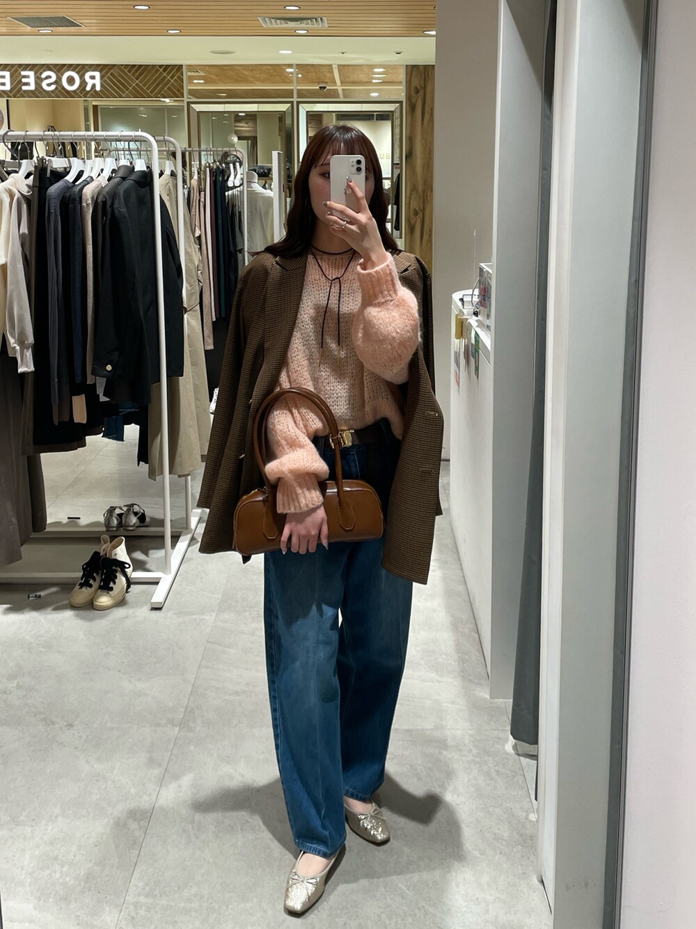 ピンク系のニット/セーター、ブラウン系のテーラードジャケット、ブルー系のデニムパンツを着用したレディースの秋コーディネートの3枚目の写真